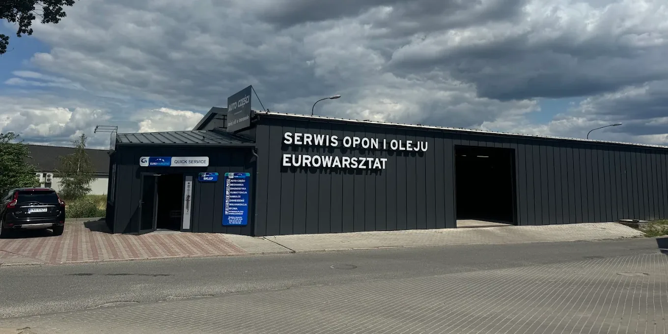 Ciemnoszary budynek Auto części Quick Service przy ulicy Kwiatowej 16 w Kępnie — nad wejściem szyld QUICK SERVICE, na ścianie napis Serwis opon i oleju Eurowarsztat